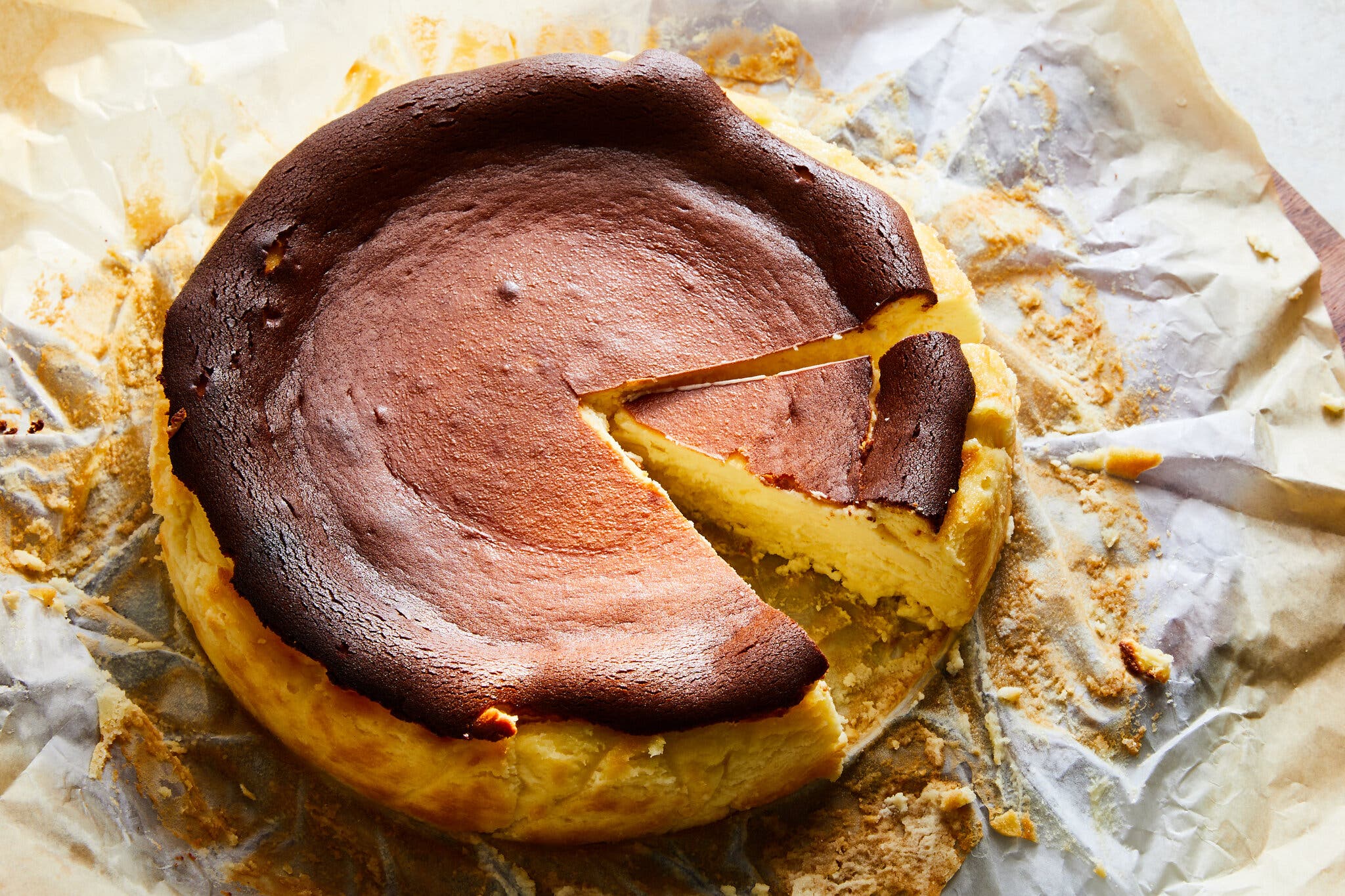 An overhead image of a burnished cheesecake with a slice taken out.