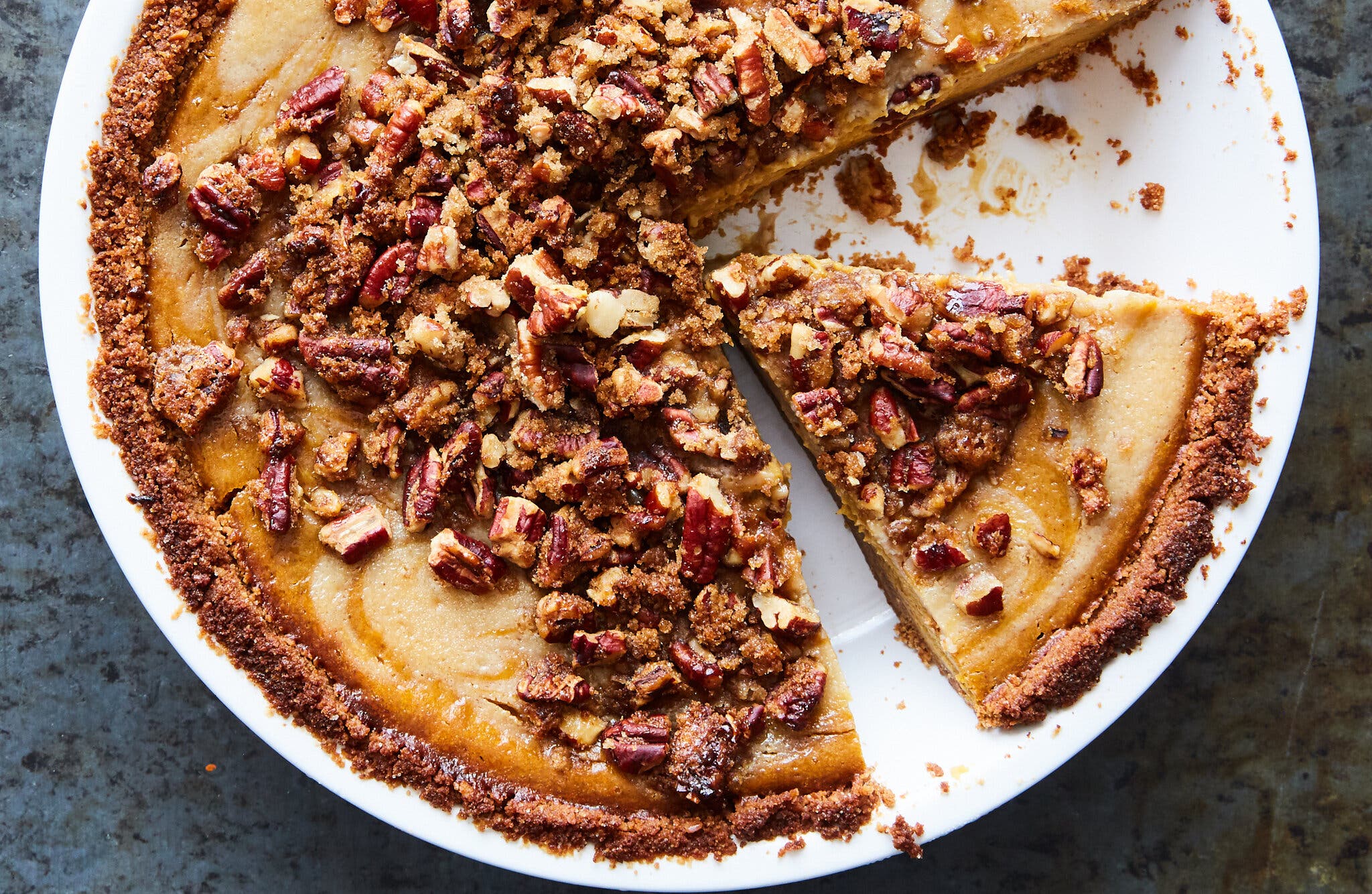 An overhead shot of a vegan pumpkin cheesecake set into a white baking dish.